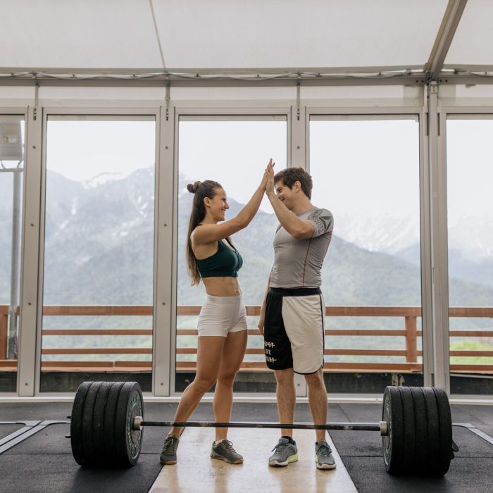Gym members celebrating progress with a high five